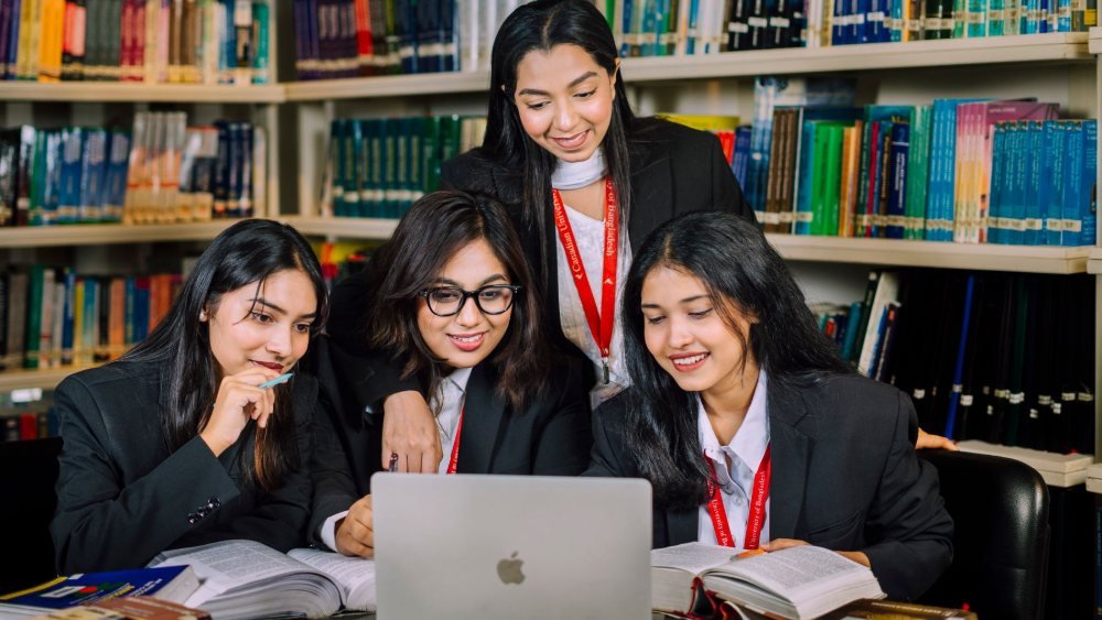 طلاب جامعيون يراجعون مواد العلوم السياسية معاً في مكتبة الجامعة