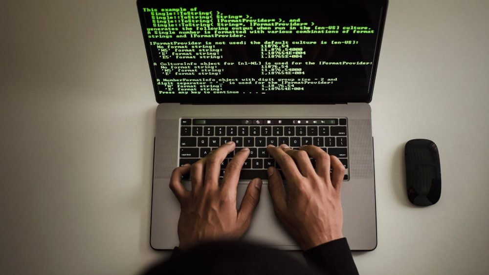 طالب يكتب شيفرة برمجية على الحاسوب المحمول خلال تدريب في أمن المعلومات