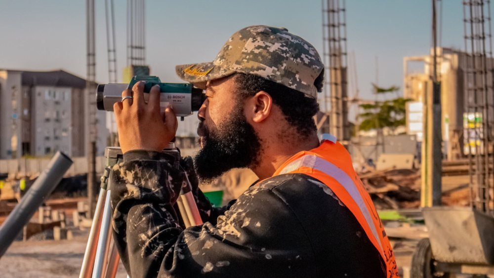 طالب هندسة مدنية يتدرب على جهاز المساحة في موقع عمل