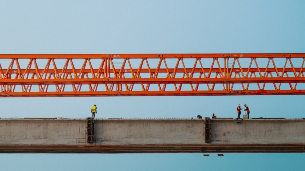 عمال ومهندسون في موقع بناء جسر ضمن مشاريع البنية التحتية