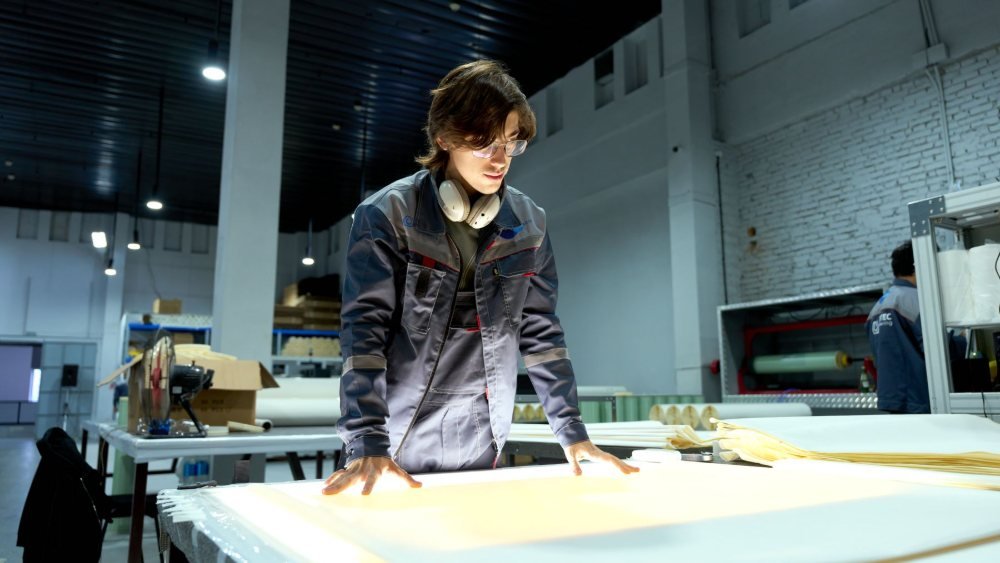 مهندس صناعي يحلل تصاميم وخطط الإنتاج في بيئة صناعية