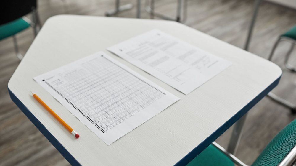 أوراق امتحان وقلم على مكتب قبل اختبار القبول للدراسات العليا